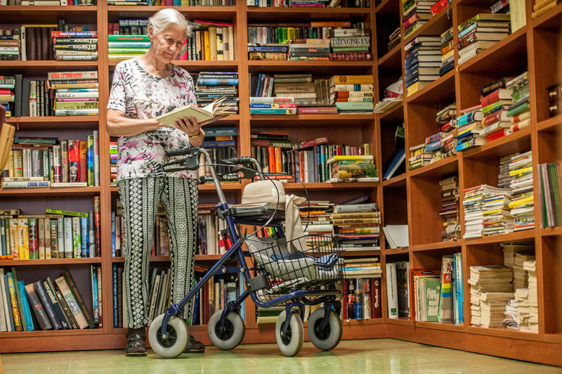 Elderly lady reading in library