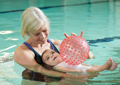 Physio in pool with patient and ball